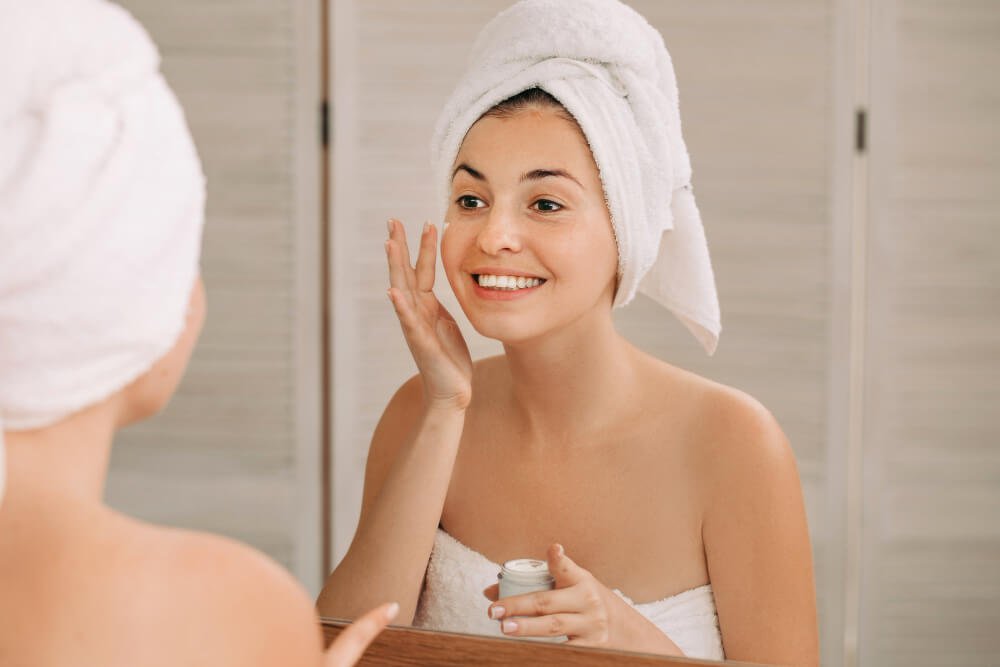 Mujer aplica crema facial con ácido hialurónico