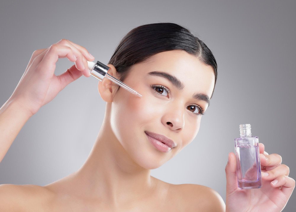 Joven aplica con gotero serum durante rutina skincare