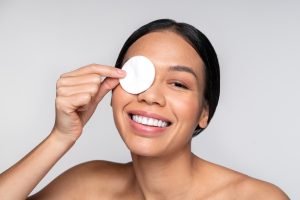 Mujer joven sonríe a la cámara durante rutina de skincare