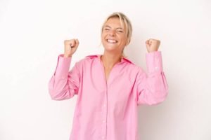 Mujer adulta celebra con los puños cerrados por probar tratamiento de rejuvenecimiento 4d de fotona sp dynamis
